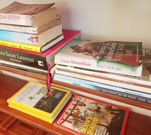 una pila di libri appoggiata su un tavolo di The Bungalow a Città del Capo