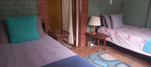 a bedroom with two twin beds and a lamp at Ground Floor apartment-2 x single beds, TV,kitchen, own bathroom, patio in Pinetown