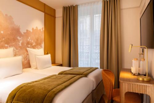 a hotel room with a bed and a window at Hôtel Le Cardinal in Paris
