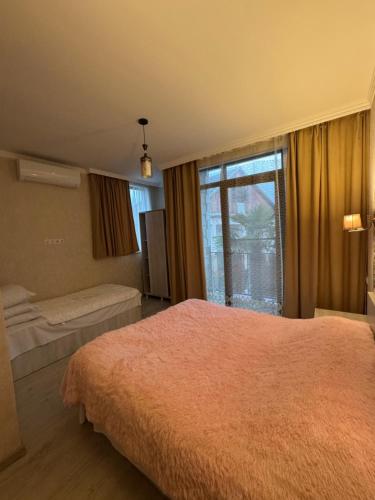 a bedroom with a large bed and a window at PAPILLON in Chakvi