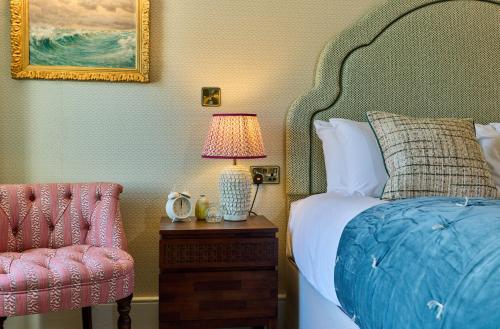 a bedroom with a bed and a lamp and a chair at The Globe Inn in Wells next the Sea
