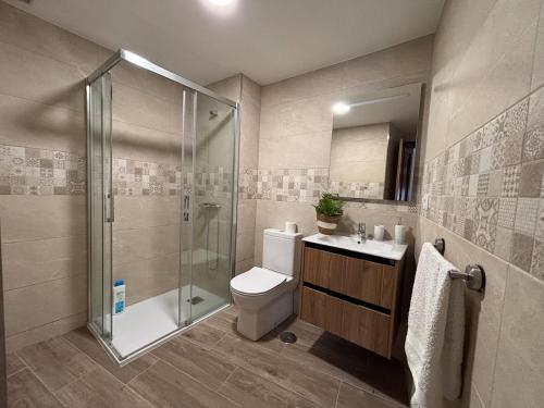 Un baño con ducha, inodoro y lavabo. en Antiuxía Muros, en Muros