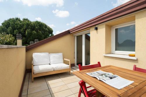 a patio with a wooden table and white chairs at EnJoy Home - Padova Pop Terrace in Padova