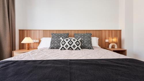 a bedroom with a large bed with pillows on it at Flacalco Hotel & Apartments in Cala Ratjada