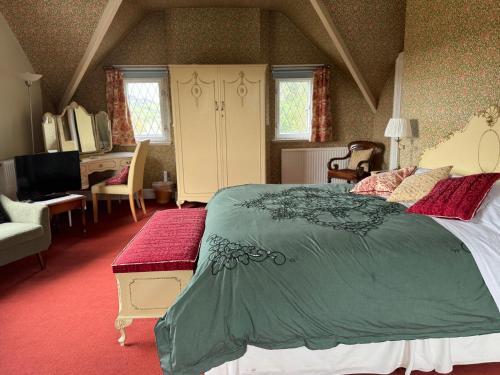 a bedroom with a large bed with a green blanket at Pentre Cerrig Country House in Llanferres
