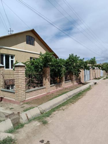 a house with a fence on the side of a street at Guest House Aziza in Bokonbayevo