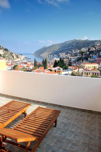 a wooden bench sitting on top of a white wall at Eos Studios in Symi
