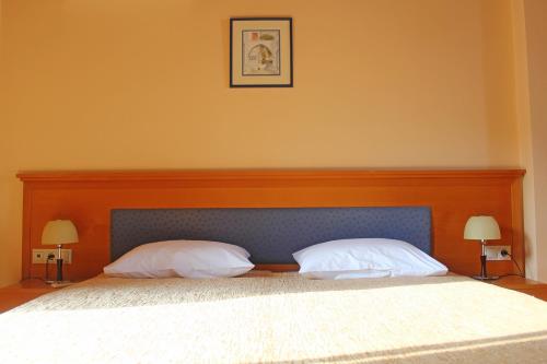 a bedroom with a large bed with two pillows at Eos Studios in Symi