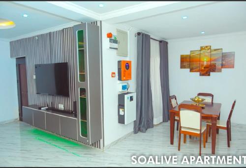 ein Wohnzimmer mit Tisch und Fernseher in der Unterkunft Soalive Apartments in Lagos