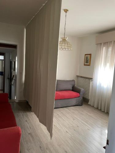 a living room with a couch and a red blanket at Margi House in Bigolino