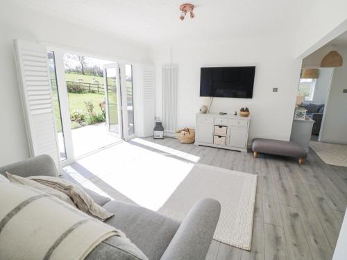 a living room with a couch and a television at New House Farm in Leamington Spa