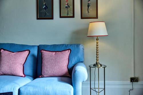 a blue couch with two pink pillows next to a lamp at The Globe Inn in Wells next the Sea