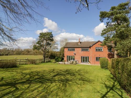 an exterior view of a large brick house at New House Farm in Leamington Spa