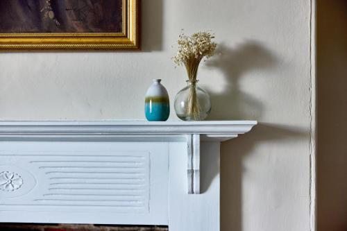 two vases sitting on top of a fireplace at The Globe Inn in Wells next the Sea