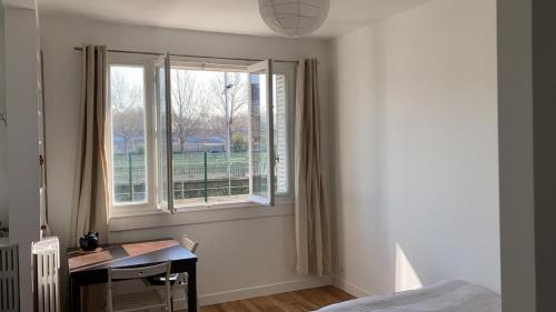 une chambre avec un lit, un bureau et une fenêtre dans l'établissement studio lumineux avec vue sur le canal, à Paris