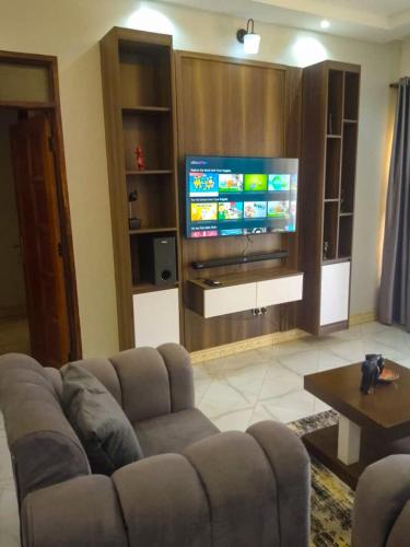 a living room with a couch and a flat screen tv at Joshean Apartments in Wakiso