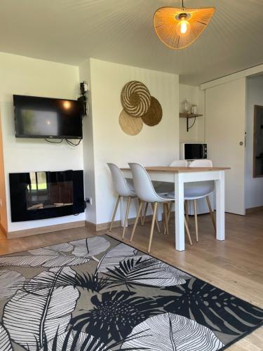 - un salon avec une table, des chaises et une télévision dans l'établissement Le nid de Poisy, à Poisy