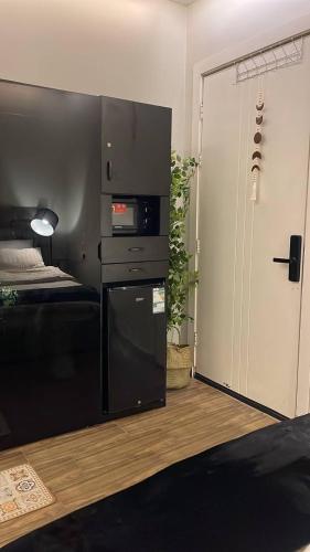 a living room with a black refrigerator and a door at استديو الجاكرندا غرناطه in Riyadh