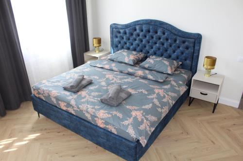 a bedroom with a blue bed with two pillows at Vārves Muiža in Vārve