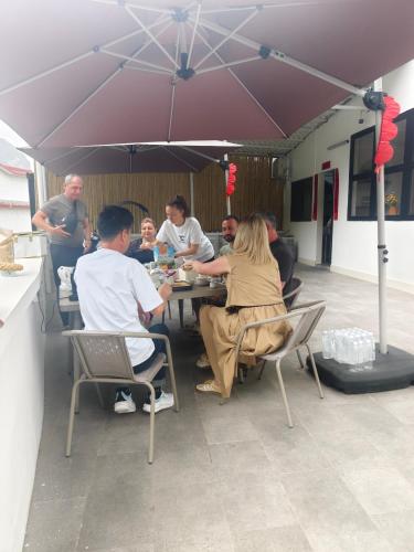a group of people sitting at a table under an umbrella at THAT MAY Hotel in Yangshuo