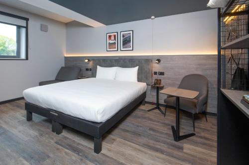 a hotel room with a bed and a desk and a chair at ibis Styles London Gatwick Airport in Crawley