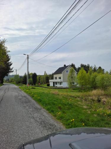 a white house on the side of a road at Apartment in the heart of Sunnmore in Vigra