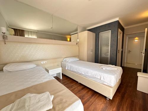 a hotel room with two beds and a mirror at Gold Butik Otel in Marmaris