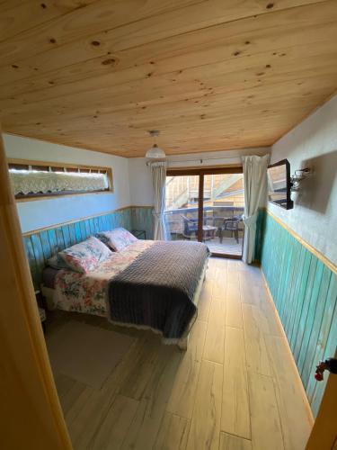a bed in a small room with a wooden floor at Hostal F in El Quisco