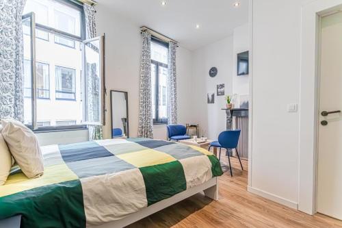 Un dormitorio con una cama y dos sillas azules. en Modern connected 6 Studios in the heart of Ghent, en Gante