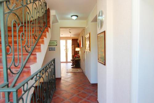 a hallway with a staircase with a wrought iron railing at Mila & Aleksandr Apartments in Budva