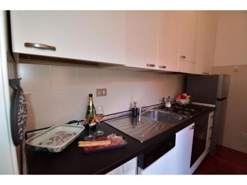 a kitchen with a sink and a counter with wine bottles at Timeless Garden Lake Como in Gravedona