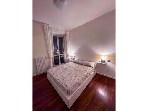 a small bedroom with a bed and a window at Timeless Garden Lake Como in Gravedona