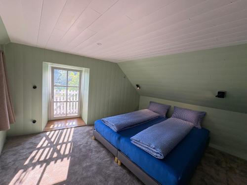 une chambre avec un lit bleu et une fenêtre dans l'établissement Maison au cœur des châteaux de la Loire - Les Glycines, à Menars