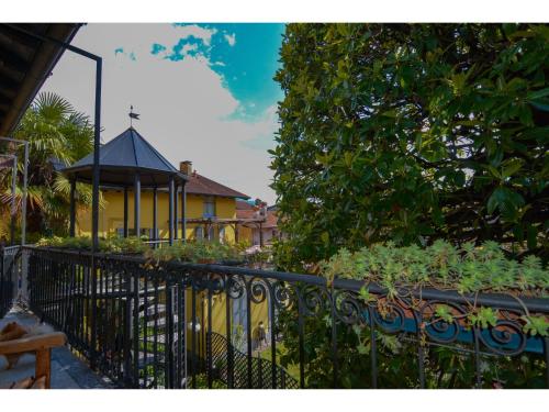 a fence in front of a house with a gazebo at Timeless Garden Lake Como in Gravedona