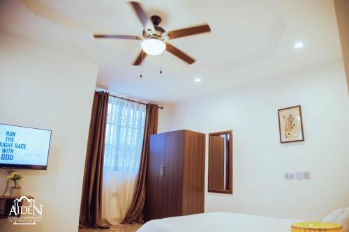a bedroom with a ceiling fan and a closet at AIDEN HOMES AND APARTMENTS HOTEl in Koforidua