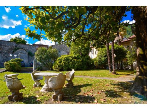 a park with a stone table and a tree at Timeless Garden Lake Como in Gravedona