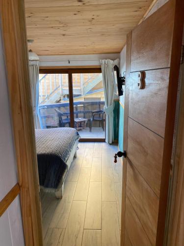 a bedroom with a bed and a door to a balcony at Hostal F in El Quisco