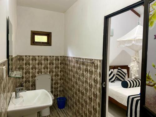 a small bathroom with a sink and a bed at Habarana New Star Homestay in Habarana