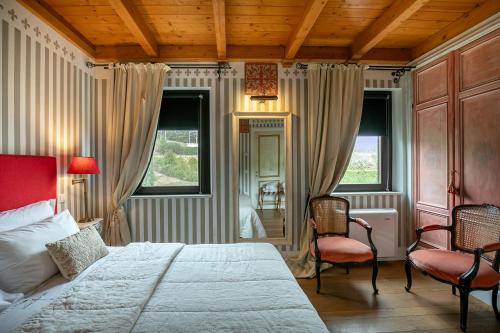 Un dormitorio con una cama grande y dos sillas. en Mandalay Lodge & Resort Senigallia, en Senigallia