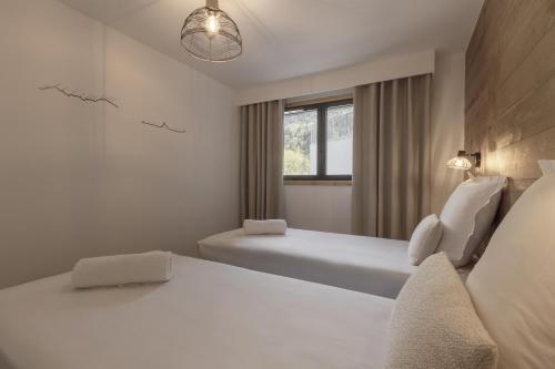 une chambre avec deux lits et une fenêtre dans l'établissement Le mazot de Kayla - Mazot de Kayla - Vue Mont-Blan, aux Houches