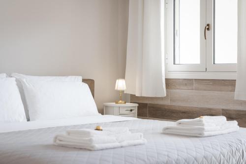 a bedroom with a bed with three towels on it at Porfyra Suite 1 in Skala