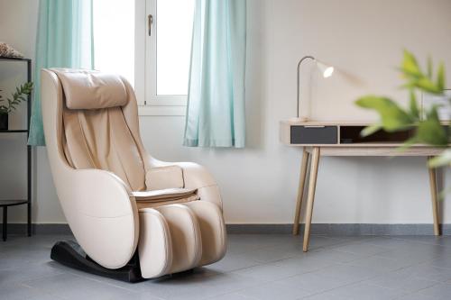 a white chair sitting next to a desk at Porfyra Suite 1 in Skala