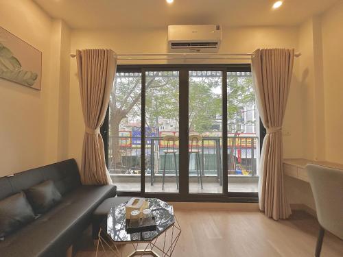 a living room with a couch and a large window at Happy Home - Big Balcony - Best Location in Hanoi