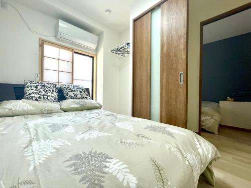 Postel nebo postele na pokoji v ubytování IMA Guesthouse 飛田新地イマ民宿