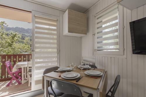 une salle à manger avec une table et des chaises et un balcon dans l'établissement Prarion Lac - Pied des pistes - Vue montagne, aux Houches