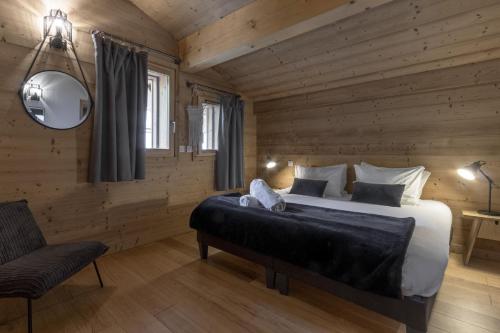 une chambre avec un grand lit et une chaise dans l'établissement Trabets 2 - Vue Montagne - 150m des Remontees, aux Houches