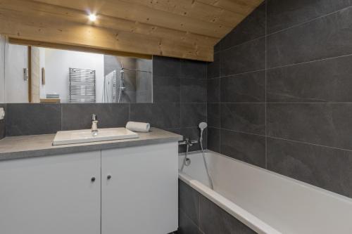 une salle de bain avec un lavabo et une baignoire dans l'établissement Trabets 2 - Vue Montagne - 150m des Remontees, aux Houches