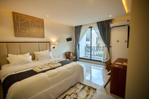 a bedroom with a large bed and a balcony at AIDEN HOMES AND APARTMENTS HOTEl in Koforidua