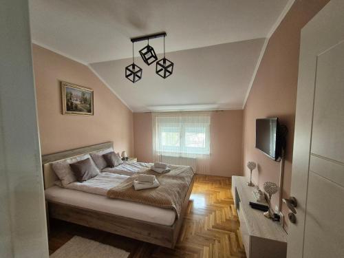 a bedroom with a bed and a tv in a room at Queen Deluxe in Sombor