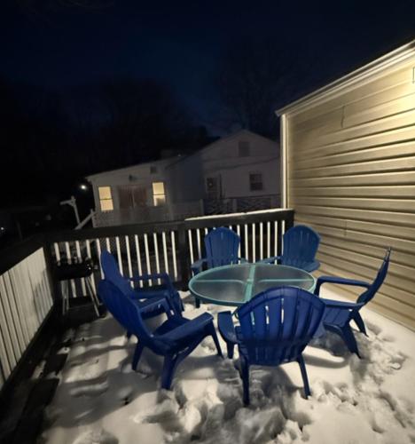 a table and chairs in the snow on a deck at Charming Retreat with Pool Table in Chesterfield! in Chesterfield